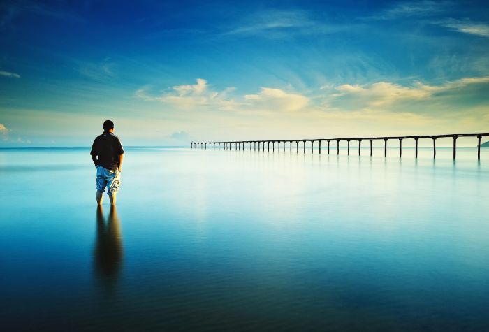 Картинка мужчина стоит в заливе перед мостом