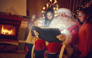 Санта Клаус (Дед Мороз) читает книгу детям
