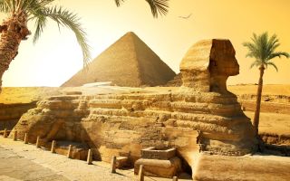 Сфинкс на фоне пирамиды Хеопса или Хуфу в городе Гизе, Египет
