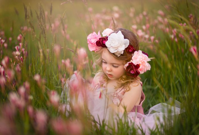 Картинка маленькая девочка, ребенок в венке из цветов сидит в траве