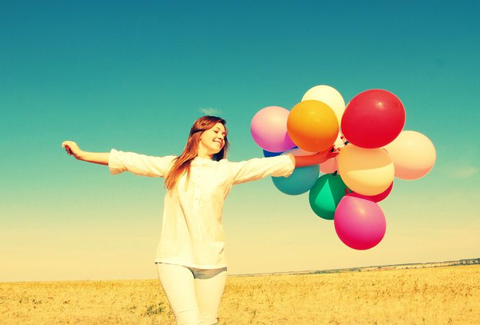 Картинка девушка с разноцветными воздушными шарами, стоит в поле