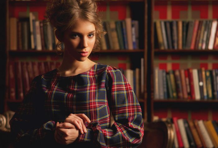 Картинка девушка модель возле книжных полок