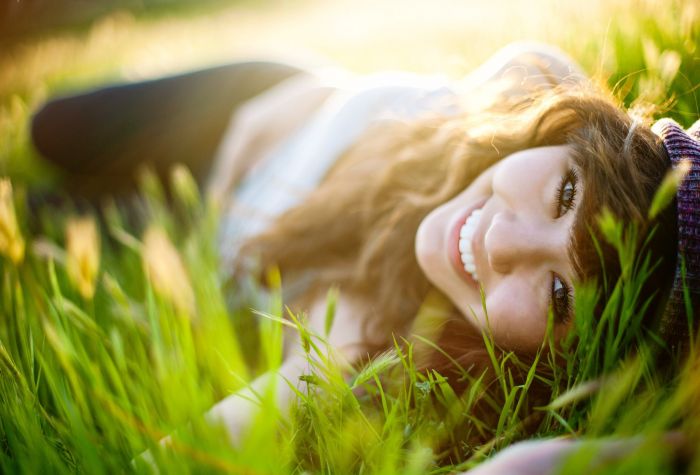 Картинка девушка с улыбкой лежит на траве