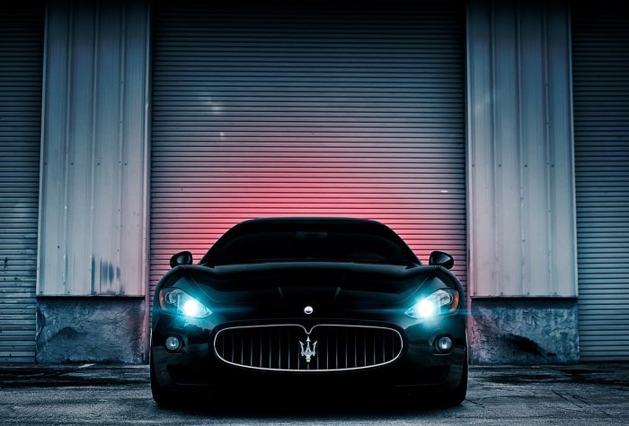 Картинка черный автомобиль Maserati с включенными фарами