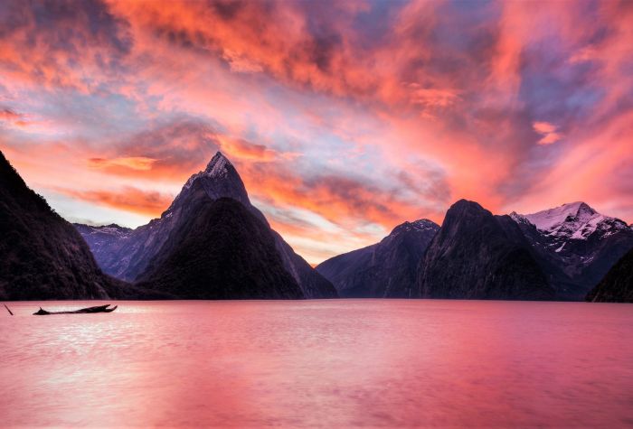 Картинка озеро на фоне острых гор на закате солнца и огненного неба
