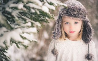 ребенок, девочка в шапке и свитере зимой возле елки