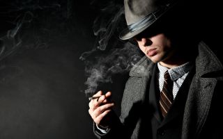 мужчина в шляпе, костюме, в пальто,с сигаретой в дыму