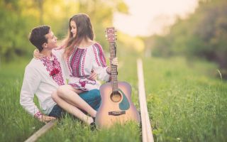 влюбленная пара в вышиванках, девушка на коленях у парня с гитарой