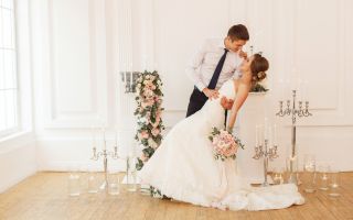 свадьба, жених держит за талию невесту в красивом платье