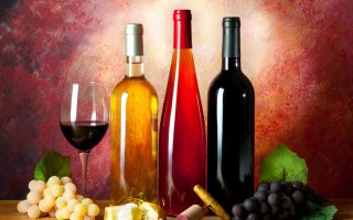бутылки с вином возле бокала и гроздей винограда, натюрморт