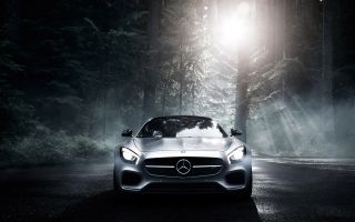красивый, серебристый Mercedes-Benz AMG ночью в темном лесу