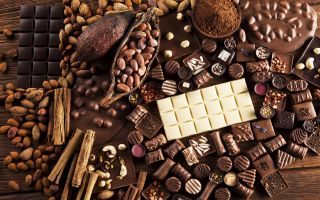 плитки шоколада, шоколадные конфеты, орехи и корица